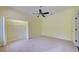 A light-filled bedroom with neutral carpet and an open closet, featuring wire shelving and storage at 7333 Royal Oak Dr, Spring Hill, FL 34607