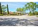 The entrance to the community, complete with a guardhouse, mature trees, and lush landscaping at 7333 Royal Oak Dr, Spring Hill, FL 34607
