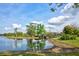 Scenic pond view featuring lush green grass and a charming wooden bridge under a cloudy sky at 7333 Royal Oak Dr, Spring Hill, FL 34607