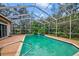 Sparkling pool area featuring a screened enclosure and lush landscaping at 7333 Royal Oak Dr, Spring Hill, FL 34607