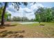 Community tennis court surrounded by mature trees and lush landscaping on a sunny day at 7333 Royal Oak Dr, Spring Hill, FL 34607