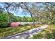 Community tennis courts surrounded by mature trees and lush landscaping, with seating areas at 7333 Royal Oak Dr, Spring Hill, FL 34607