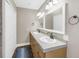 Bathroom featuring a double sink vanity with tile countertops and decorative light fixtures at 742 45Th Ne Ave, St Petersburg, FL 33703