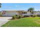Beautiful home with a manicured lawn, lush landscaping, light brick, and a driveway at 742 45Th Ne Ave, St Petersburg, FL 33703