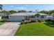 Charming single-story home featuring a well-manicured lawn, metal roof, and attached two car garage at 742 45Th Ne Ave, St Petersburg, FL 33703