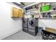 Well-equipped laundry room featuring modern washer and dryer, storage cabinets, and durable epoxy flooring at 742 45Th Ne Ave, St Petersburg, FL 33703