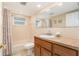 Bathroom with a combined tub and shower, a single sink vanity, and a large framed mirror at 7426 Cay Dr, Port Richey, FL 34668