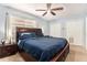 Main bedroom featuring blue walls, ceiling fan, and large bed with matching nightstands at 7426 Cay Dr, Port Richey, FL 34668
