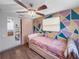 Bedroom featuring a low bed, ceiling fan, hardwood floors, and geometric wall decor at 8210 68Th N Way, Pinellas Park, FL 33781