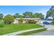 Charming single-story home with a well-maintained lawn and a blue car in the driveway at 8210 68Th N Way, Pinellas Park, FL 33781