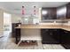 Open kitchen with dark cabinets, tan countertops and tile floor, featuring pendant lighting at 8210 68Th N Way, Pinellas Park, FL 33781