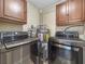 Laundry area equipped with a modern washer, dryer, and water heater, plus overhead cabinets at 8210 68Th N Way, Pinellas Park, FL 33781