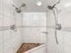 Bright tiled shower featuring two shower heads, decorative inlays, and a built-in corner bench at 8210 68Th N Way, Pinellas Park, FL 33781