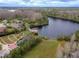Aerial view showcasing a community park with a playground, gazebo, and a pier on a serene lake at 8219 Summer Brook Ct, Land O Lakes, FL 34638