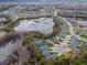An aerial view shows an upscale community bordering a large lake, neighborhood with homes, ponds, and landscaping at 8219 Summer Brook Ct, Land O Lakes, FL 34638