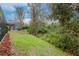 Private backyard with lush greenery, a screen enclosed lanai and a glimpse of a tranquil view at 8219 Summer Brook Ct, Land O Lakes, FL 34638