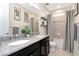 Elegant bathroom featuring dual sinks, granite countertops, and tiled shower with neutral-toned decor at 8219 Summer Brook Ct, Land O Lakes, FL 34638