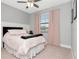 Calm bedroom featuring neutral walls, window with pink curtains, and a comfy bed with matching decor at 8219 Summer Brook Ct, Land O Lakes, FL 34638