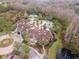 An aerial view of a community clubhouse with swimming pools, palm trees, and ample parking at 8219 Summer Brook Ct, Land O Lakes, FL 34638