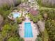 Overhead view of the community clubhouse featuring pools, tropical landscaping, and a parking area at 8219 Summer Brook Ct, Land O Lakes, FL 34638