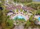 Aerial view of the community clubhouse with pools, palm trees and landscaping, near a parking area at 8219 Summer Brook Ct, Land O Lakes, FL 34638