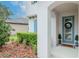 Home's charming entrance boasts beautiful landscaping and a welcoming front door with wreath at 8219 Summer Brook Ct, Land O Lakes, FL 34638