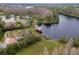 Aerial view showcasing a community park with playground, gazebo, and a pier on a serene lake at 8219 Summer Brook Ct, Land O Lakes, FL 34638
