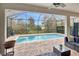 Inviting screened-in pool with brick patio, lush landscaping, and outdoor seating at 8219 Summer Brook Ct, Land O Lakes, FL 34638