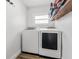 Laundry room includes modern washer and dryer with overhead shelving for storage at 8240 Jacaranda Ave, Seminole, FL 33777