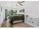 Comfortable main bedroom featuring a ceiling fan, a large window and a decorative dresser at 8240 Jacaranda Ave, Seminole, FL 33777