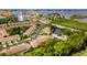 Gorgeous aerial view of the waterfront community featuring mature landscaping, a pond, and community pool at 11246 Kapok Grand Cir, Madeira Beach, FL 33708