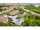 Aerial view of a beautiful community with a pool, pond, and lush landscaping at 11246 Kapok Grand Cir, Madeira Beach, FL 33708
