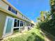 Townhome backyard featuring a private patio area, lush lawn, and partial landscaping at 11246 Kapok Grand Cir, Madeira Beach, FL 33708