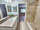 Bathroom featuring a tiled shower, vanity with sink, and a view into the bedroom at 11246 Kapok Grand Cir, Madeira Beach, FL 33708