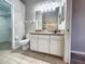Bright bathroom with tile flooring, large mirror, and white cabinetry offering ample storage space at 11246 Kapok Grand Cir, Madeira Beach, FL 33708