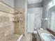 Bathroom with tan tile shower, neutral walls, tiled floors, and a single sink vanity at 11246 Kapok Grand Cir, Madeira Beach, FL 33708