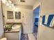 Bathroom with vanity and mirror, next to a bedroom with blue bed at 11246 Kapok Grand Cir, Madeira Beach, FL 33708
