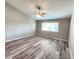 A bright, empty bedroom with laminated wood flooring and a large window at 11246 Kapok Grand Cir, Madeira Beach, FL 33708