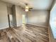 Bright bedroom with hardwood floors, neutral walls, ceiling fan, and an ensuite bathroom at 11246 Kapok Grand Cir, Madeira Beach, FL 33708