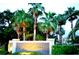 Kapok Grand neighborhood monument sign surrounded by palm trees, shrubbery and green grass at 11246 Kapok Grand Cir, Madeira Beach, FL 33708