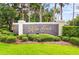 Elegant Kapok Grand community sign surrounded by manicured landscaping and mature trees at 11246 Kapok Grand Cir, Madeira Beach, FL 33708
