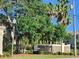 Kapok Grand community sign with mature shade trees, palms, and manicured landscaping at 11246 Kapok Grand Cir, Madeira Beach, FL 33708