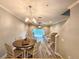 Cozy dining area featuring a round wooden table and elegant chandelier, perfect for intimate meals at 11246 Kapok Grand Cir, Madeira Beach, FL 33708