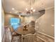 Open-concept dining room showcasing a round table, elegant lighting, and seamless flow into the living area at 11246 Kapok Grand Cir, Madeira Beach, FL 33708