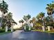 A community entrance framed by tall palm trees with an iron security gate at 11246 Kapok Grand Cir, Madeira Beach, FL 33708