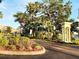 Community entrance featuring landscaping, palms, and gated access at 11246 Kapok Grand Cir, Madeira Beach, FL 33708
