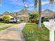 Traditional townhome with a neutral color scheme, attached garage, mature landscaping, and a private driveway at 11246 Kapok Grand Cir, Madeira Beach, FL 33708