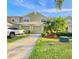 Two-story townhome featuring attached garages, a well-manicured lawn, and green landscaping at 11246 Kapok Grand Cir, Madeira Beach, FL 33708