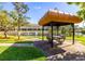 Relaxing gazebo with seating beside a pond with fountain, perfect for enjoying the outdoors at 11246 Kapok Grand Cir, Madeira Beach, FL 33708