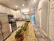 Open kitchen with stainless steel appliances and granite countertops overlooks the dining and living area at 11246 Kapok Grand Cir, Madeira Beach, FL 33708